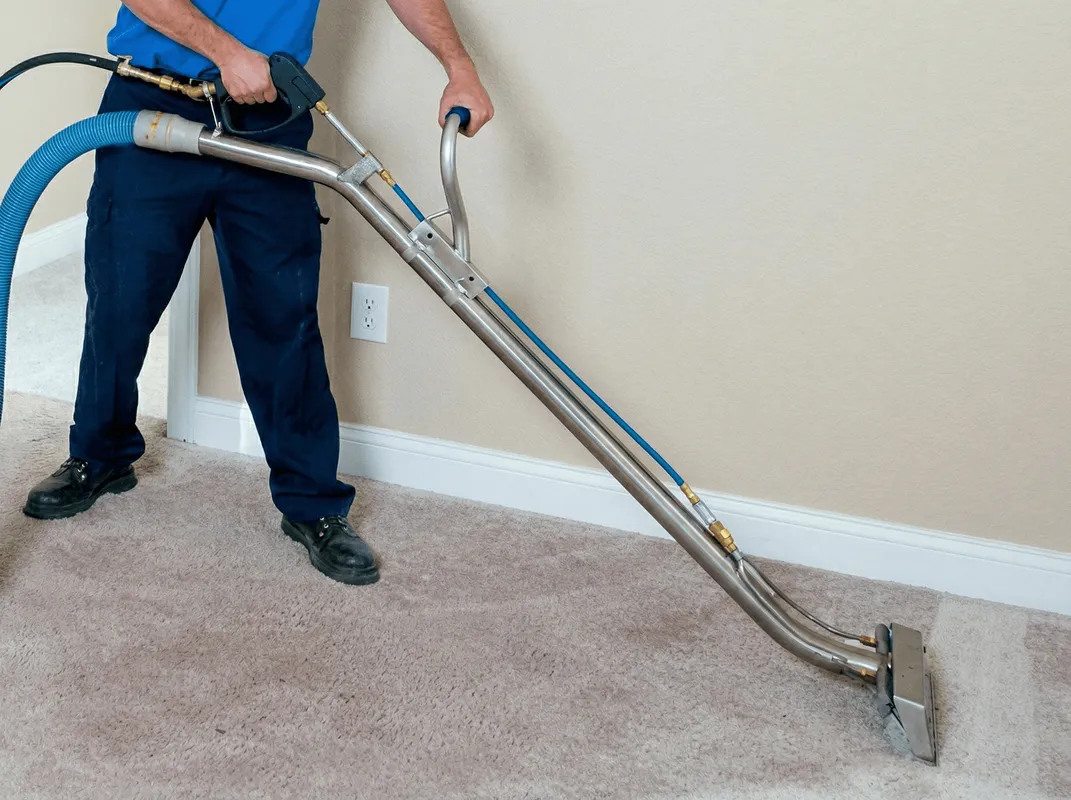 Professional operating a liquid removal machine on a carpeted floor in Staten Island, NY